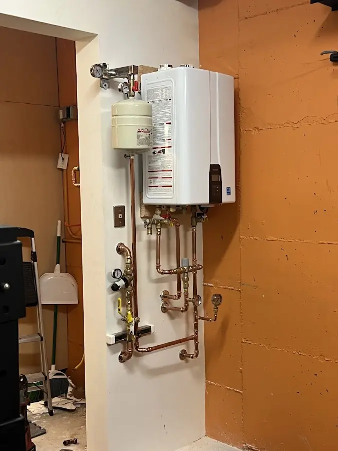Plumbing technician inspecting water heater connections in Lake Park